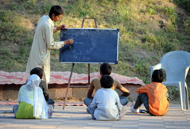 Пакистанский студент-доброволец обучает детей. Это, скорее всего, его личная инициатива: еще не западная школа, но уже не медресе