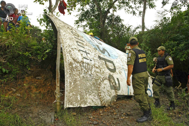 Police and local residents work to lift a piece of what local media is calling a piece of an Ariane space rocket near Salinopolis